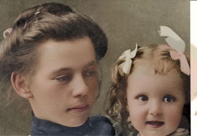 Restored and colorized (AI-assisted); faces are the original photo, colours are a best guess. Lydia Mae Bowles Coffman with an infant daughter (uploader: 'Lydia Boles Daughter'; offered on Obera Coffman, 1902-1904).