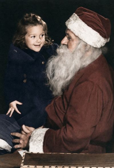 Restored and colorized with AI from the original, c. 1947. Colours are a best guess. Nancy Coffman as a small girl, with Santa Claus, c. 1947.