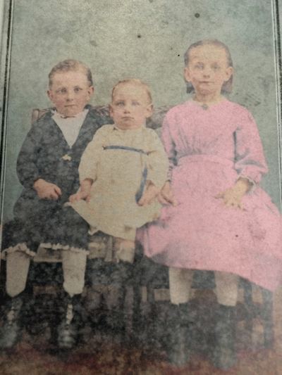 Restored and colorized (AI-assisted); faces are the original photo, colours are a best guess. Clarence, Ruth and Ella Martin as children.
