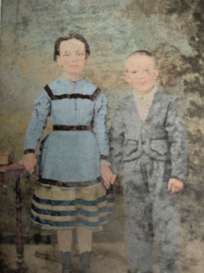 Restored and colorized (AI-assisted); faces are the original photo, colours are a best guess. Ella and Clarence Martin, children of David B. and Sue Martin.